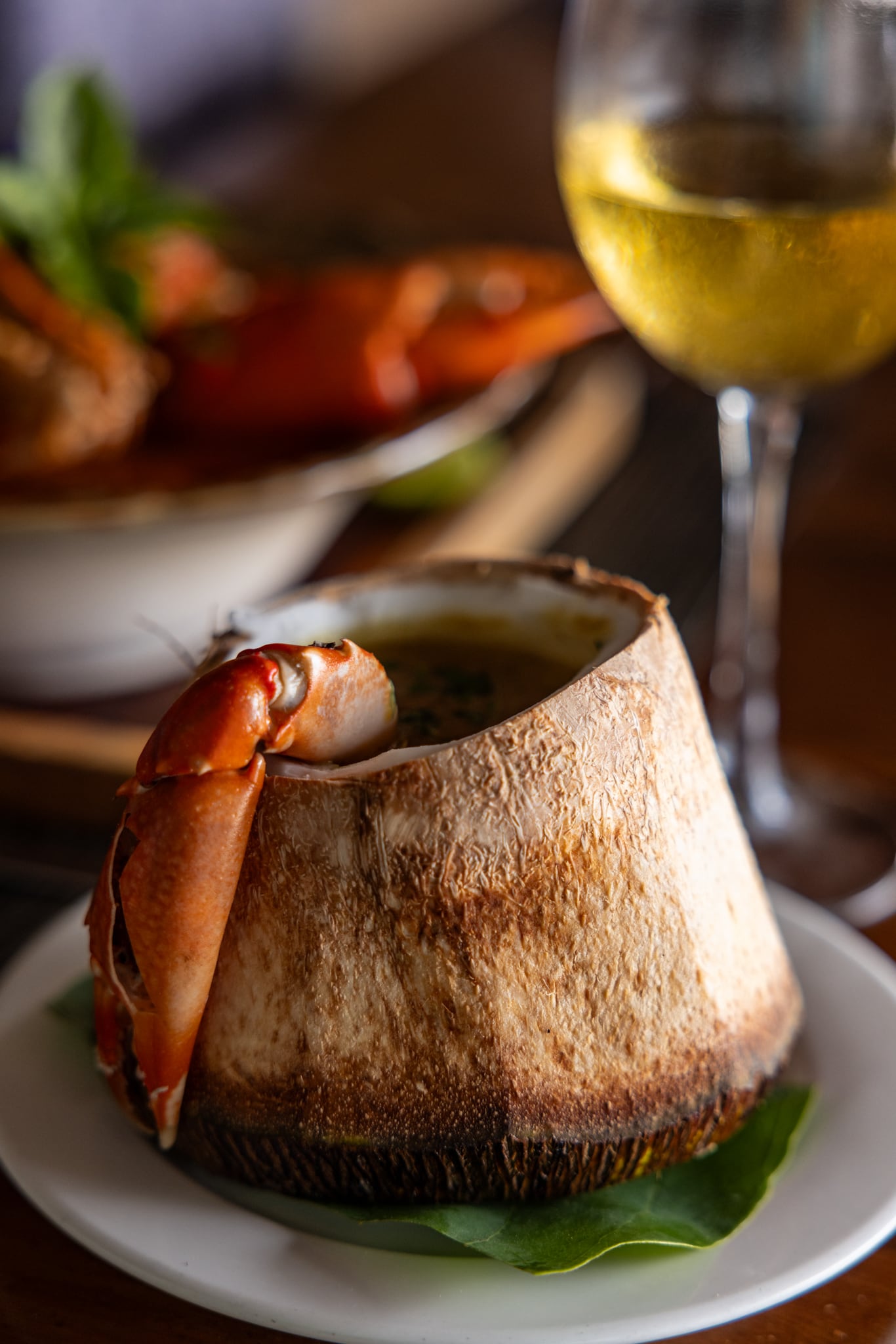 Crab served in a coconut shell at Zatiny, with a glass of white wine.