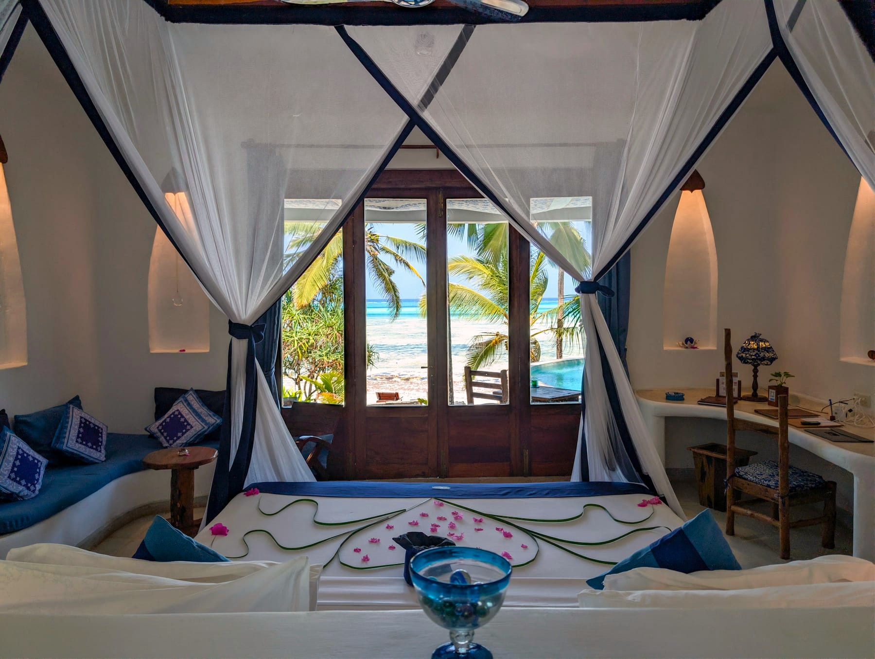 View from the bed in Room Maji at Asili House, Boutique Hotel Matlai Zanzibar, showing balcony, pool, and ocean.
