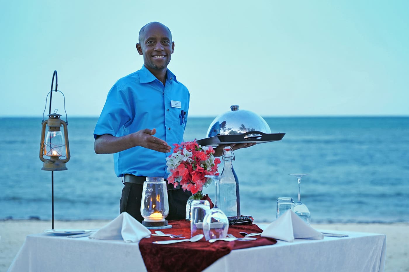 butler serving meals on the beach of the Indian ocean