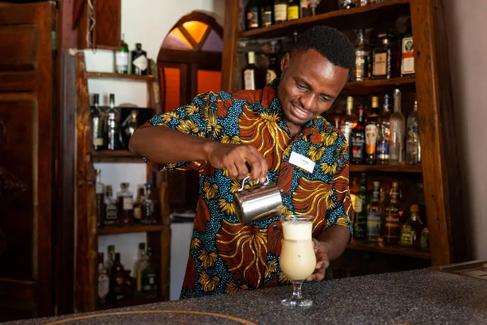 Barkeeper preparing a cocktail with joy at Zatiny Bar, Boutique Hotel Matlai Zanzibar.
